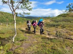 Kolme vaeltajaa auringonpaisteessa