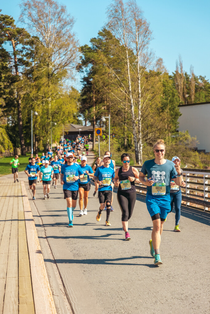 Ryhmä juoksioita juoksee kameraa kohti kauniissa säässä.